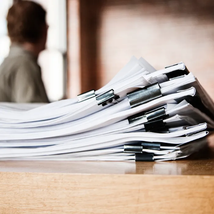 Fascicolo con documentazione tecnica su tavolo in legno