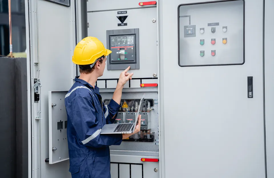 Tecnico al lavoro su pannello elettrico di controllo